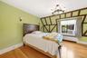 Bedroom featuring exposed timber framing and light wood-finish flooring