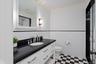 Full bathroom featuring ornamental molding, vanity, a stall shower, tile walls, and a wainscoted wall