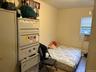Bedroom with wood finished floors, cooling unit, and baseboard heating