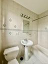 Bathroom with tile patterned floors, tub / shower combination, and tile walls