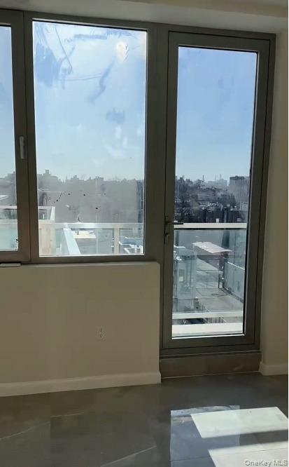 Doorway with a view of city and concrete flooring