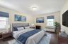 Bedroom with radiator heating unit and dark colored carpet