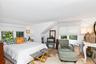 Bright interior featuring light wood-finish flooring and multiple windows with white blinds