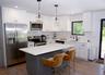 Kitchen with appliances with stainless steel finishes, backsplash, white cabinetry, a kitchen island, and hanging light fixtures
