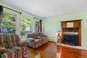 Living area with dark wood-style floors, crown molding, a fireplace, and baseboard heating