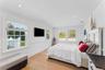Bedroom with light wood floors and wainscoted walls.