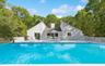 View of pool featuring a patio and view of scattered trees