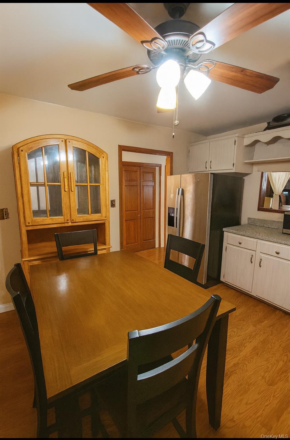 Dining space with light wood finished floors and ceiling fan