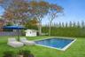 View of heated swimming pool with a fenced backyard, a storage shed, and a patio area