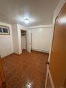 Unfurnished bedroom with a closet, baseboard heating, and light flooring