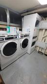 Shared laundry room featuring stacked washing machine and dryer and independent washer and dryer