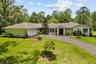 Welcoming front elevation featuring a long paved driveway