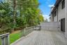 Spacious outdoor deck featuring wood decking, a privacy screen, and direct access to a grassy yard