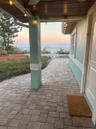 A large 33-foot covered front porch, perfect for relaxing in any weather. with three fans, string lights, wood soffits, and quality oversized chairs,