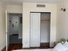 Bedroom with dark wood-type flooring and a closet