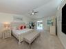 The primary suite includes two large walk in closets, private en-suite, and sliding glass door access to the lanai for late night dips