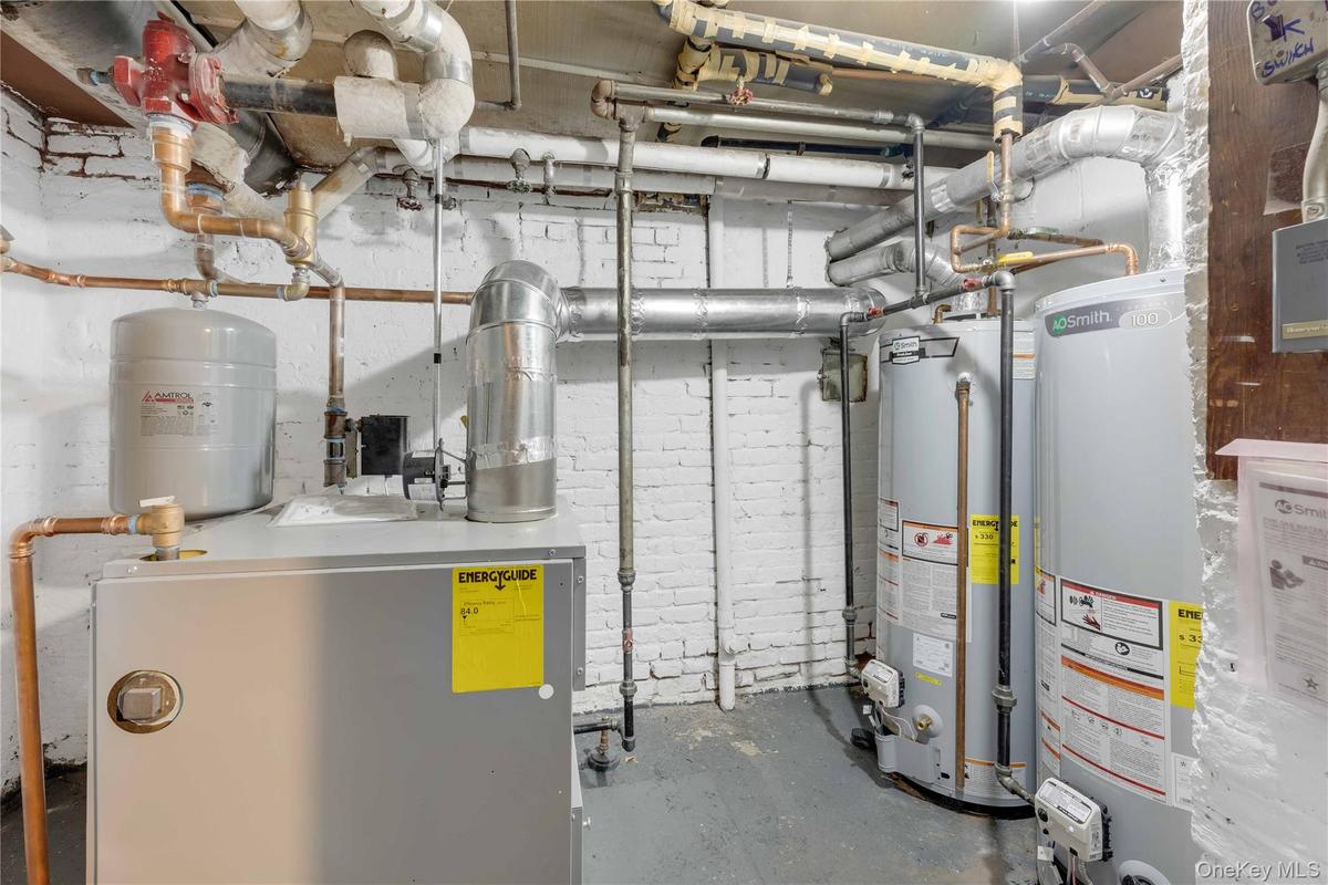 Utility room featuring a heating unit and gas water heater