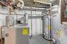 Utility room featuring a heating unit and gas water heater