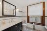 Bathroom with tile walls, radiator heating unit, vanity, a wainscoted wall, and light tile patterned floors