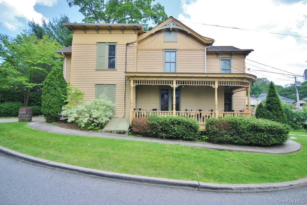 View of front of house with a front yard and a porch