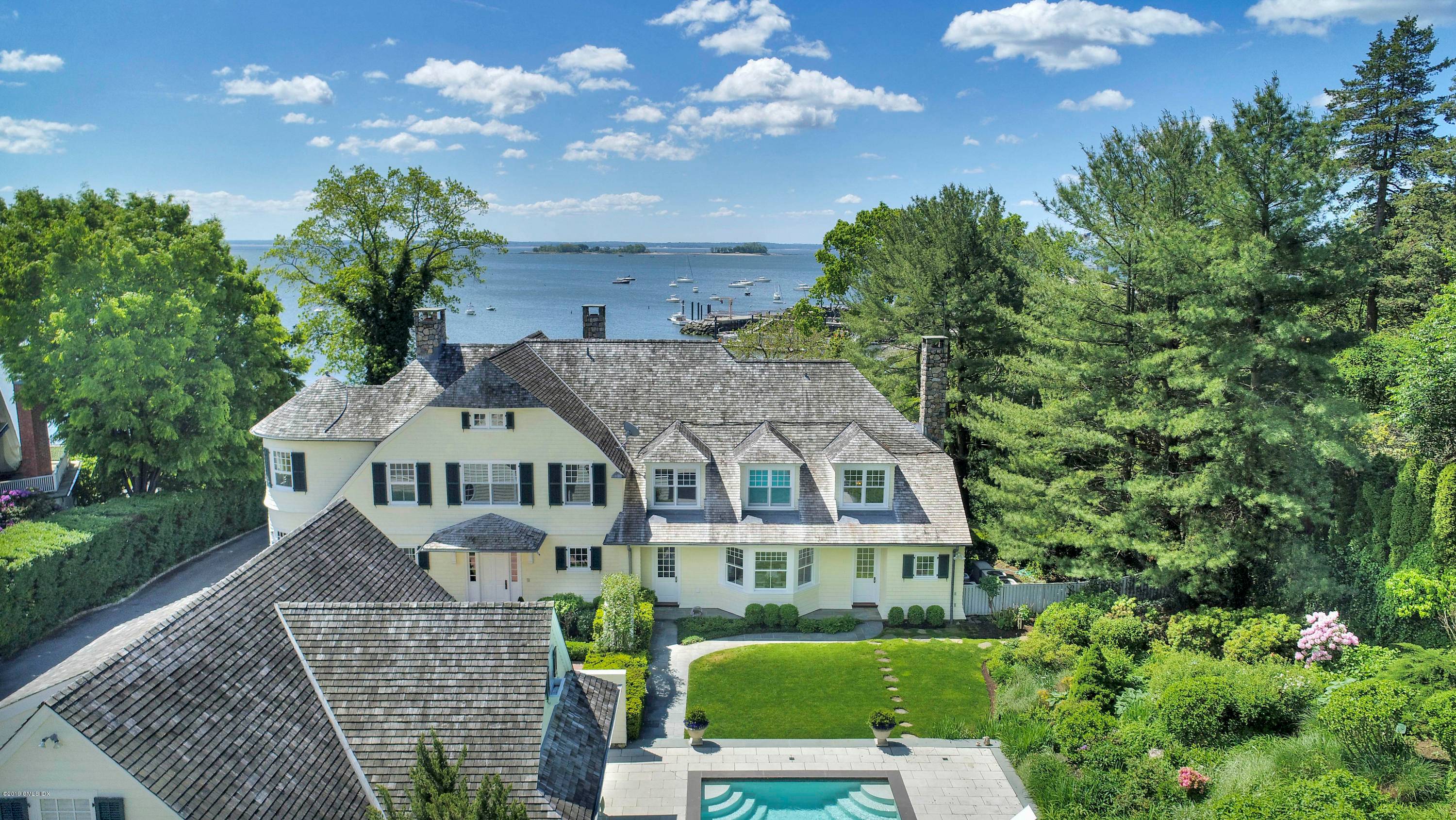 Spectacular custom shingle style Colonial showcases captivating water views from all rooms in this serene waterside retreat with pool, pool house and lush garden in Belle Haven steps from the ...