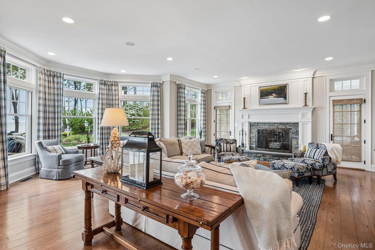 Spacious family room featuring 6" wide planked flooring and a woodburning fireplace