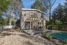 Back of property with a fenced backyard, a wooden deck, and a pergola