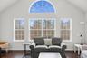 Living room with high vaulted ceiling, baseboards, and wood finished floors