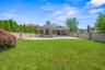 Back of property with a gazebo, a patio, brick siding, and a fenced backyard