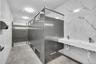 Bathroom with elevator, tile walls, and double vanity