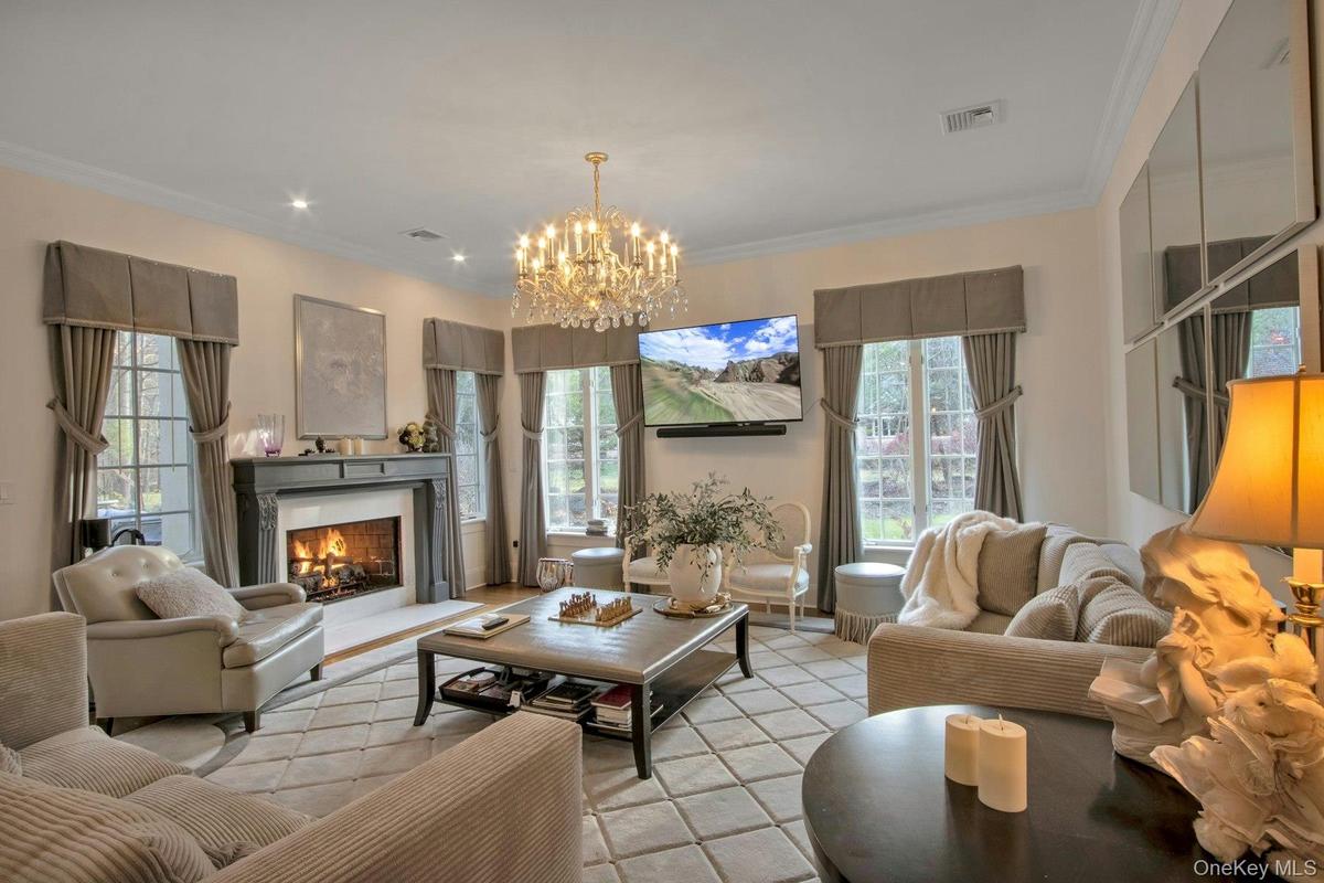 Family room with crown molding and an inviting chandelier