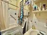 Full bathroom featuring tile walls, shower / bath combo with shower curtain, and vanity