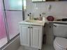 Full bathroom with vanity, combined bath / shower with glass door, and tile walls