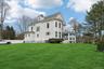 Rear view of property with a yard, a chimney, and a sunroom