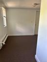 Carpeted empty room with baseboard heating