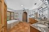 Spa-Inspired Primary Bathroom with Large Soaking Tub, Oversized Walk-In Tiled Shower, Dual Vanities & Private Water Closet