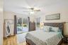 Bedroom with hardwood / wood-style flooring, a ceiling fan, and access to outside