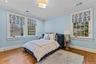 Bedroom featuring detailed molding and wood finished floors.