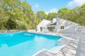View of pool featuring outdoor dining space, a patio area, a gate, and view of scattered trees