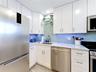 Your custom kitchen has under counter lighting, glass shelves and a beautiful backsplash along new cabinets and appliances.
