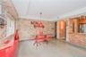 Unfurnished dining area with brick wall, light wood finished floors, a raised ceiling, and recessed lighting