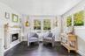 Living area with healthy amount of natural light, a lit fireplace, and dark wood-type flooring