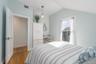 Bedroom with light wood-style flooring, lofted ceiling, and baseboards