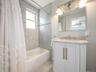 Bathroom with shower / bath combo, vanity, light tile patterned flooring, and ceiling fan