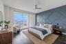 The primary bedroom features a striking custom accent wall that adds architectural depth and modern sophistication. Painted in a rich slate blue, the