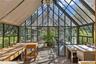 Spacious greenhouse with potting benches, utility sink, and abundant natural light for year-round cultivation