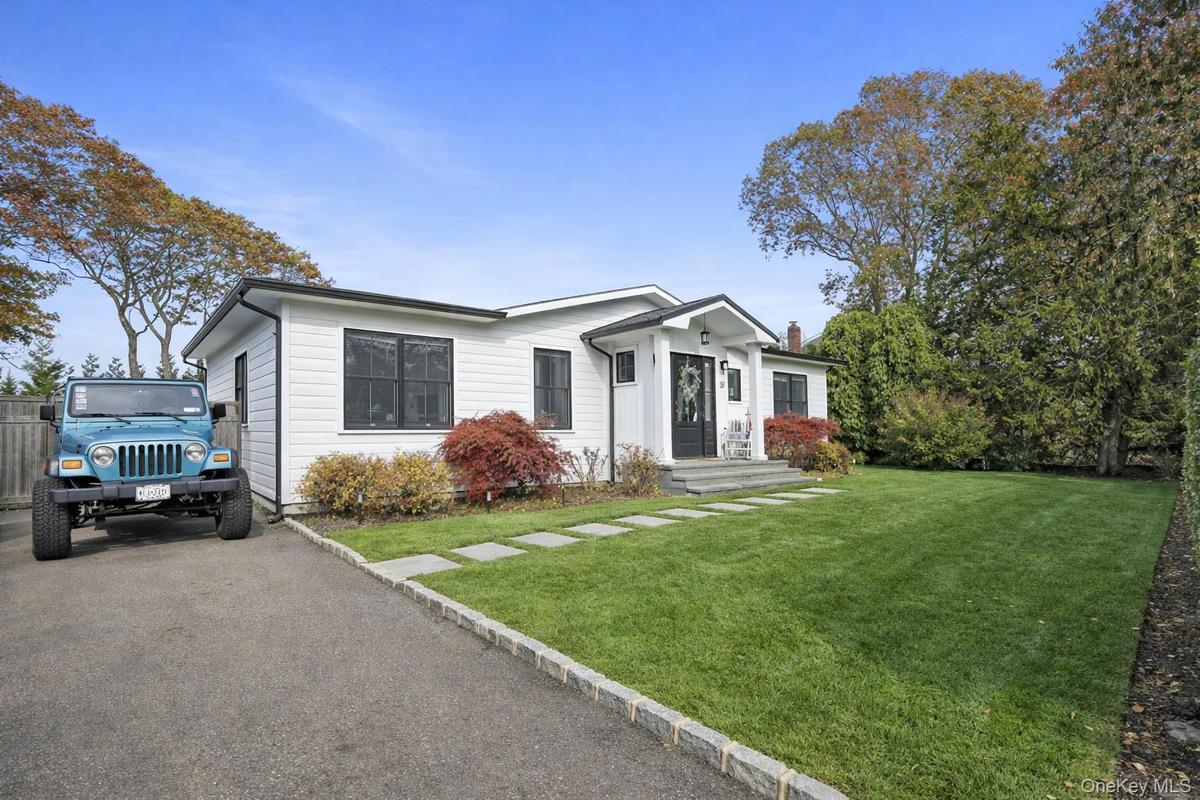 View of front facade featuring a front lawn and driveway