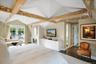 Bedroom featuring dark wood finished floors, a glass covered fireplace, and access to outside