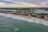A reverse angle captures the southern horizon, dotted with colorful homes and calm estuary waters, emphasizing the secluded charm of this community.