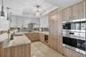 Spectacular kitchen w/ custom bleached walnut veneer cabinetry by renowned Chicago based millworker. Grain matches from top to bottom. Taj mahal quart
